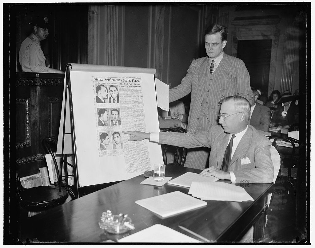 Harris and Ewing, 1939 — the auto lobbyist points to enlarged police mugshots of union organizers at a Senate hearing