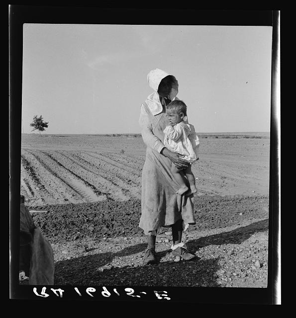 Dorothea Lange, 1937 — a mother and child, flood refugees; her face hidden by a bonnet