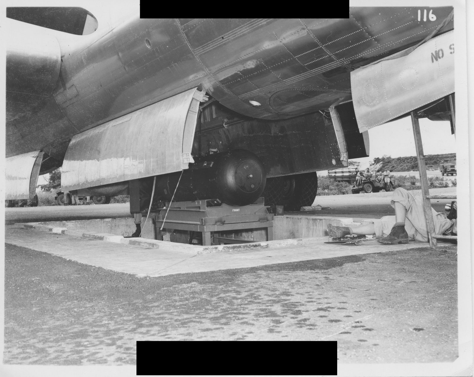 Little Boy atomic bomb on trailer cradle being loaded into the bomb bay of the Enola Gay, Tinian Island, August 1945