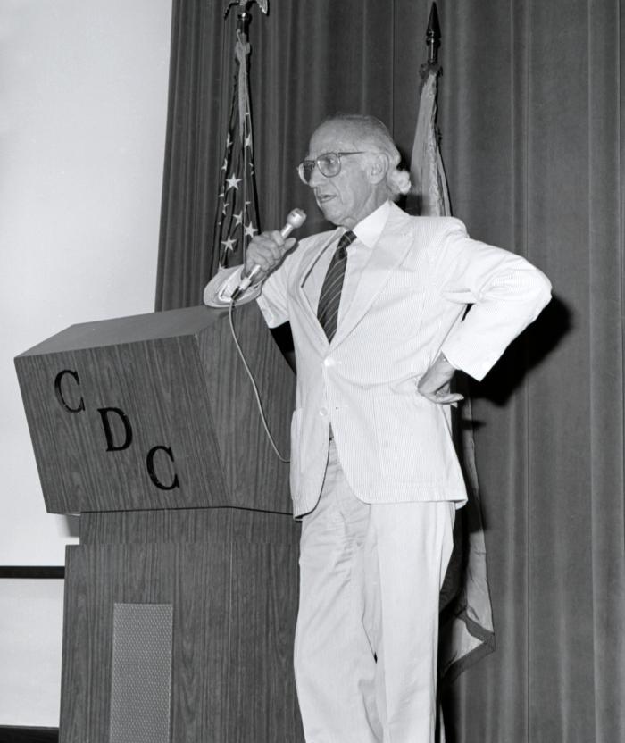 Dr. Jonas Salk speaking at the podium during a 1988 visit to the CDC