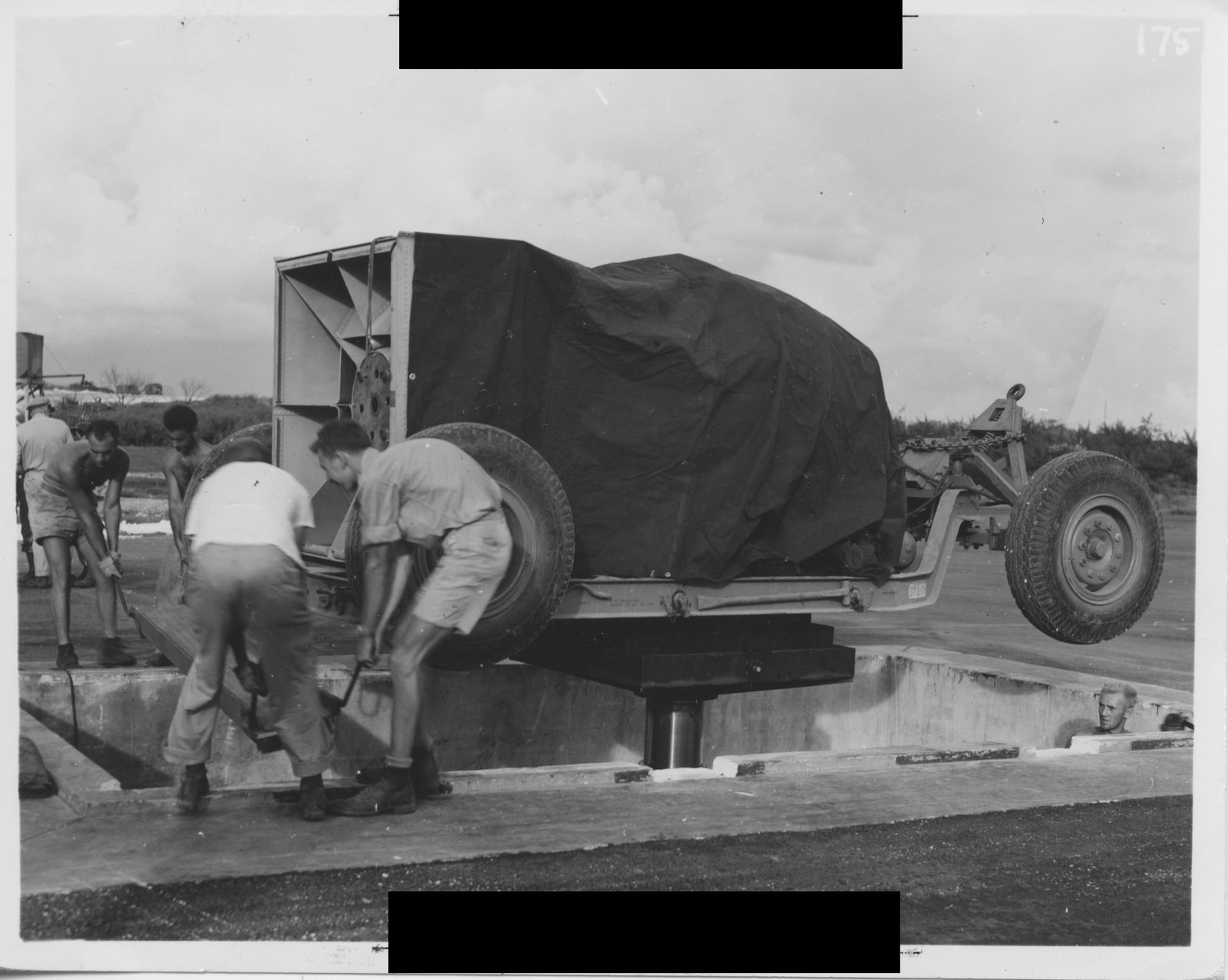 Enlisted men moving atomic bomb equipment on a concrete pad at Tinian Island, August 1945